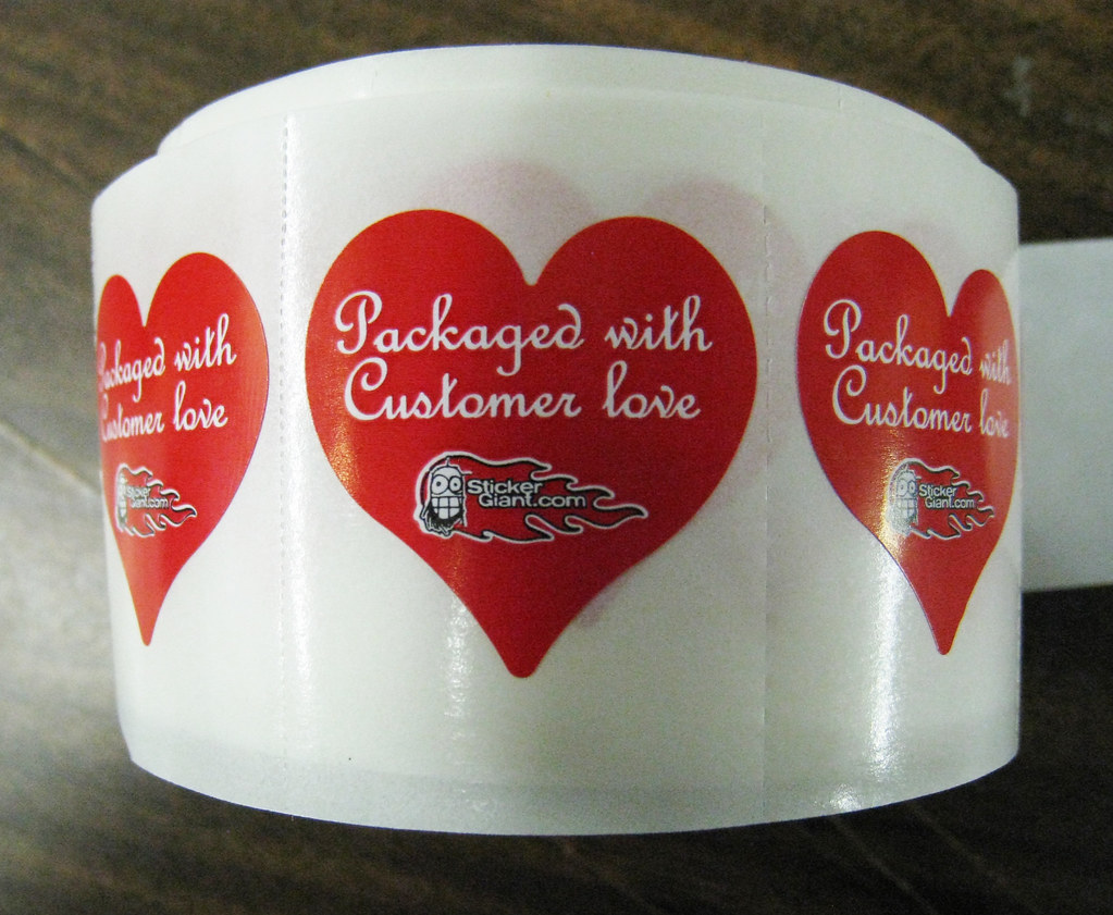 a roll of heart shaped labels with the words packaged with customer love on them